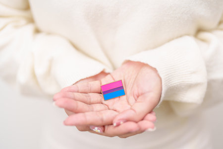 Bisexuality Celebrate Day and LGBT pride month, LGBTQ or LGBTQIA concept. Hand holding purple, pink and blue flag shape for Lesbian, Gay, Bisexual, Transgender, Queer, Pansexual, Marriage Equality Lawの写真素材