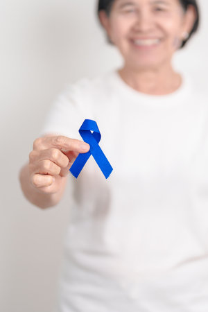 Elderly with dark Blue or Navy blue Ribbon for concept of March Colorectal and Colon Cancer Awareness month, May Arthritis awareness, July Juvenile arthritis and Childhood. Health and world cancer dayの写真素材