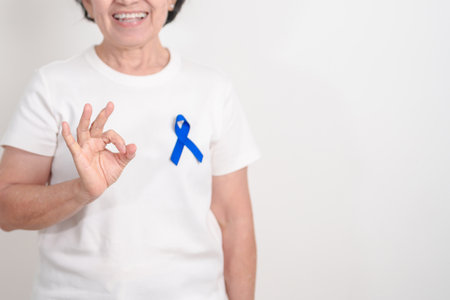 Elderly with dark Blue or Navy blue Ribbon for concept of March Colorectal and Colon Cancer Awareness month, May Arthritis awareness, July Juvenile arthritis and Childhood. Health and world cancer dayの写真素材