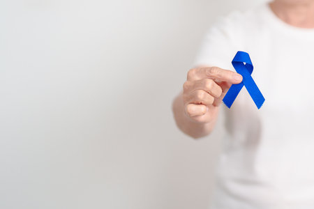 Elderly with dark Blue or Navy blue Ribbon for concept of March Colorectal and Colon Cancer Awareness month, May Arthritis awareness, July Juvenile arthritis and Childhood. Health and world cancer dayの写真素材