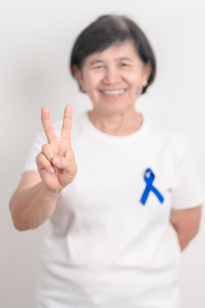 Elderly with dark Blue or Navy blue Ribbon for concept of March Colorectal and Colon Cancer Awareness month, May Arthritis awareness, July Juvenile arthritis and Childhood. Health and world cancer dayの写真素材