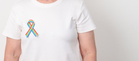 Elderly with LGBTQ Rainbow ribbon for concept of June Pride month, April Autism Awareness, All cancer Awareness, February World Cancer day, October World Hospice and Palliative care day and Survivorの写真素材
