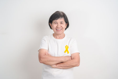 Elderly with Yellow Ribbon for concept of yellow September, Suicide prevention day, Childhood, July Sarcoma, bone cancer Awareness in children month, support survivor. Healthcare and World Cancer dayの写真素材