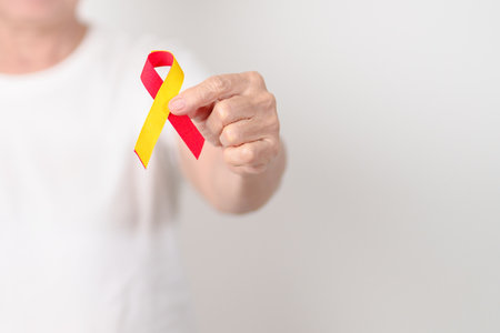 World hepatitis day awareness month, 28 July. elderly woman with Red and Yellow ribbon. Liver cancer, Jaundice, Cirrhosis, Failure, Enlarged, Hepatic Encephalopathy and Health conceptの写真素材