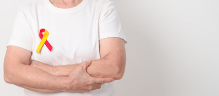 World hepatitis day awareness month, 28 July. elderly woman with Red and Yellow ribbon. Liver cancer, Jaundice, Cirrhosis, Failure, Enlarged, Hepatic Encephalopathy and Health conceptの写真素材