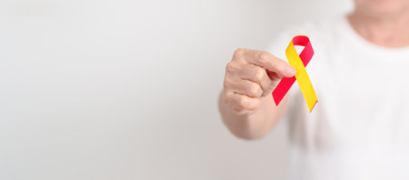 World hepatitis day awareness month, 28 July. elderly woman with Red and Yellow ribbon. Liver cancer, Jaundice, Cirrhosis, Failure, Enlarged, Hepatic Encephalopathy and Health conceptの写真素材
