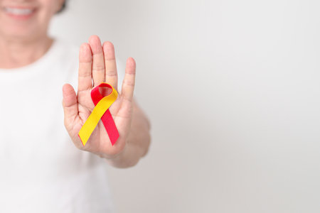 World hepatitis day awareness month, 28 July. elderly woman with Red and Yellow ribbon. Liver cancer, Jaundice, Cirrhosis, Failure, Enlarged, Hepatic Encephalopathy and Health conceptの写真素材