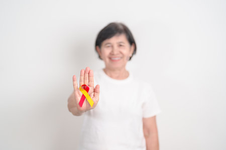 World hepatitis day awareness month, 28 July. elderly woman with Red and Yellow ribbon. Liver cancer, Jaundice, Cirrhosis, Failure, Enlarged, Hepatic Encephalopathy and Health conceptの写真素材