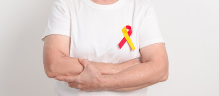 World hepatitis day awareness month, 28 July. elderly woman with Red and Yellow ribbon. Liver cancer, Jaundice, Cirrhosis, Failure, Enlarged, Hepatic Encephalopathy and Health conceptの写真素材