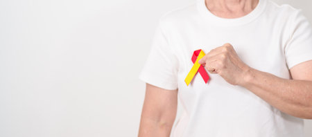 World hepatitis day awareness month, 28 July. elderly woman with Red and Yellow ribbon. Liver cancer, Jaundice, Cirrhosis, Failure, Enlarged, Hepatic Encephalopathy and Health conceptの写真素材