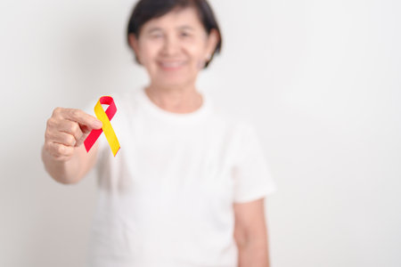 World hepatitis day awareness month, 28 July. elderly woman with Red and Yellow ribbon. Liver cancer, Jaundice, Cirrhosis, Failure, Enlarged, Hepatic Encephalopathy and Health conceptの写真素材