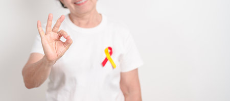World hepatitis day awareness month, 28 July. elderly woman with Red and Yellow ribbon. Liver cancer, Jaundice, Cirrhosis, Failure, Enlarged, Hepatic Encephalopathy and Health conceptの写真素材