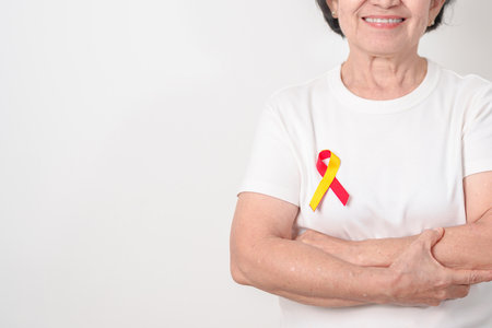 World hepatitis day awareness month, 28 July. elderly woman with Red and Yellow ribbon. Liver cancer, Jaundice, Cirrhosis, Failure, Enlarged, Hepatic Encephalopathy and Health conceptの写真素材