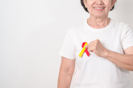 World hepatitis day awareness month, 28 July. elderly woman with Red and Yellow ribbon. Liver cancer, Jaundice, Cirrhosis, Failure, Enlarged, Hepatic Encephalopathy and Health conceptの写真素材