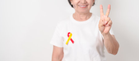World hepatitis day awareness month, 28 July. elderly woman with Red and Yellow ribbon. Liver cancer, Jaundice, Cirrhosis, Failure, Enlarged, Hepatic Encephalopathy and Health conceptの写真素材