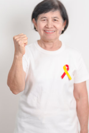 World hepatitis day awareness month, 28 July. elderly woman with Red and Yellow ribbon. Liver cancer, Jaundice, Cirrhosis, Failure, Enlarged, Hepatic Encephalopathy and Health conceptの写真素材