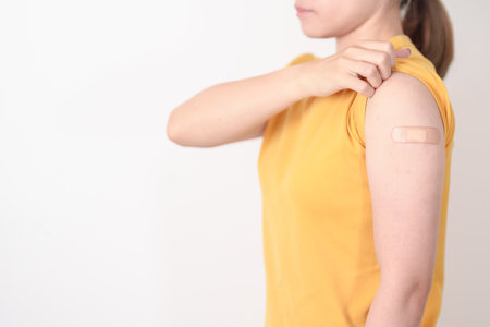 Adult Woman with bandage after received vaccine. Vaccination and Immunization for Influenza, HPV, Zoster, IPD, DTP or Diphtheria, Tetanus and Pertussis, MMR, Hepatitis B, Covid and Varicella vaccineの写真素材