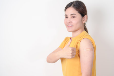 Adult Woman with bandage after received vaccine. Vaccination and Immunization for Influenza, HPV, Zoster, IPD, DTP or Diphtheria, Tetanus and Pertussis, MMR, Hepatitis B, Covid and Varicella vaccineの写真素材