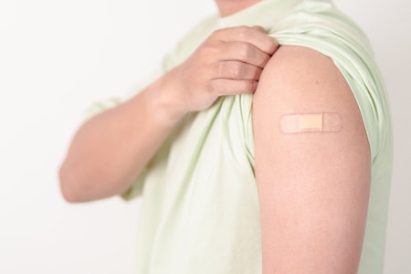 Adult Man with bandage after received vaccine. Vaccination and Immunization for Influenza, HPV, Zoster, IPD, DTP or Diphtheria, Tetanus and Pertussis, MMR, Hepatitis B, Covid and Varicella vaccineの写真素材