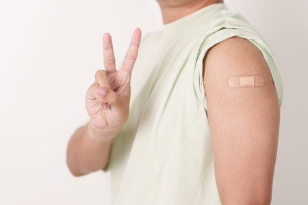 Adult Man with bandage after received vaccine. Vaccination and Immunization for Influenza, HPV, Zoster, IPD, DTP or Diphtheria, Tetanus and Pertussis, MMR, Hepatitis B, Covid and Varicella vaccineの写真素材