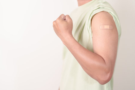 Adult Man with bandage after received vaccine. Vaccination and Immunization for Influenza, HPV, Zoster, IPD, DTP or Diphtheria, Tetanus and Pertussis, MMR, Hepatitis B, Covid and Varicella vaccineの写真素材