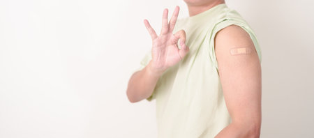 Adult Man with bandage after received vaccine. Vaccination and Immunization for Influenza, HPV, Zoster, IPD, DTP or Diphtheria, Tetanus and Pertussis, MMR, Hepatitis B, Covid and Varicella vaccineの写真素材