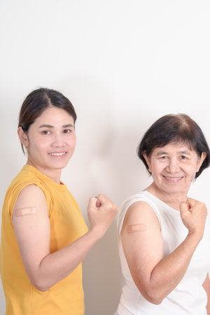 Adult and Elderly Woman with bandage after received vaccine. Vaccination and Immunization for Influenza, HPV, Zoster, IPD, DTP, Dengue, Encephalitis, Rabies, Pneumococcal Hepatitis B and Covid vaccineの写真素材