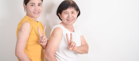 Adult and Elderly Woman with bandage after received vaccine. Vaccination and Immunization for Influenza, HPV, Zoster, IPD, DTP, Dengue, Encephalitis, Rabies, Pneumococcal Hepatitis B and Covid vaccineの写真素材