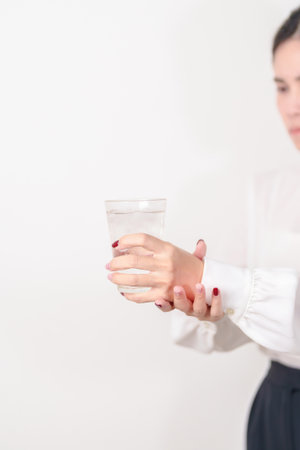Business woman having Tremor hand during hold water glass. Parkinson disease April awareness month, Carpal Tunnel Syndrome, rheumatoid and brain injury, Neurological disorder and health care conceptの写真素材
