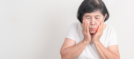 Elderly woman having Toothache and pain. Oral Teeth decay and Gum disease, Scrape off tartar. March Oral health, Dentist Day, False Teeth. Toothache and Dental Health Month and Orthodontic Health Dayの写真素材