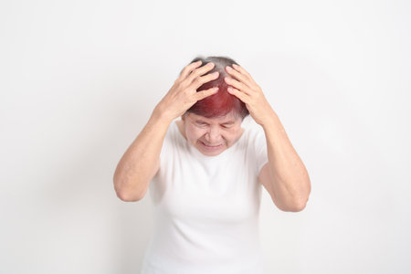 Elderly Woman having headache and Dizzy for concepts of Chronic Stress, Headache and Migraine, World Brain Tumor day, Brain Cancer, Brain Stroke, Dementia, alzheimer, Hypotension and mental healthの写真素材