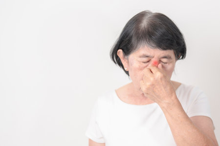 Elderly  Woman having Nose pain for concepts of Nose disease, Common Cold, Influenza, Flu, Covid 19, Respiratory Infection, Sinusitis, Allergic Rhinitis, Asthma, Allergy, Dry nose Anosmia and Healthの写真素材
