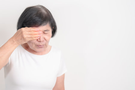 Elderly Woman having Eye pain and Irritation for concepts of Eye disease, Cataract, Glaucoma, Age Related Macular Degeneration, Diabetic Retinopathy, dry eyes, Conjunctivitis, World Glaucoma dayの写真素材