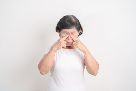 Elderly  Woman having Nose pain for concepts of Nose disease, Common Cold, Influenza, Flu, Covid 19, Respiratory Infection, Sinusitis, Allergic Rhinitis, Asthma, Allergy, Dry nose Anosmia and Healthの写真素材