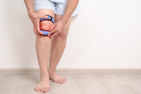 Elderly woman having knee ache with knee support brace for concepts of Runners Knee or Patellofemoral Pain Syndrome, osteoarthritis, arthritis, rheumatism and Patellar Tendinitis. Senior health careの写真素材