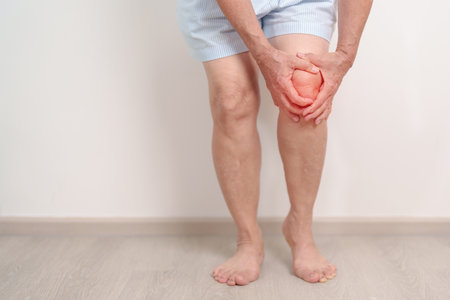 Elderly woman having knee ache and muscle pain due to Runners Knee or Patellofemoral Pain Syndrome, osteoarthritis, arthritis, rheumatism and Patellar Tendinitis. Senior health and medical conceptの写真素材