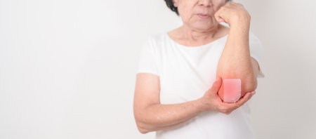 Elderly Woman having elbow ache with Medicated pain relief patch plaster for concepts of Tennis Elbow, muscle pain and Sprain, lateral epicondylitis, Bursitis, injury, Senior Health care and medicalの写真素材