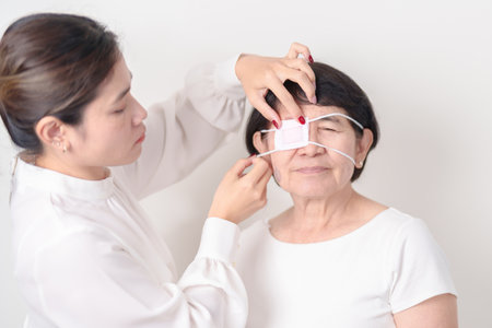Elderly Woman with Eye protecting by Eye Pad for concepts of Eye disease, Cataract, Glaucoma, Age Related Macular Degeneration, Diabetic Retinopathy, Vitreous, Conjunctivitis, World Glaucoma dayの写真素材