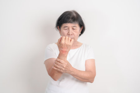 Elderly Woman having wrist pain with Medicated pain relief patch plaster for Carpal Tunnel Syndrome, Wrist Tendinitis, muscle ache, De Quervain s tenosynovitis, Hand Osteoarthritis and Senior healthの写真素材