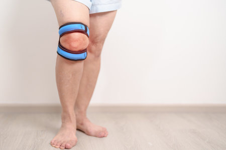 Elderly woman having knee ache with knee support brace for concepts of Runners Knee or Patellofemoral Pain Syndrome, osteoarthritis, arthritis, rheumatism and Patellar Tendinitis. Senior health careの写真素材