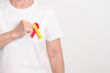 World hepatitis day awareness month, 28 July. elderly woman with Red and Yellow ribbon. Liver cancer, Jaundice, Cirrhosis, Failure, Enlarged, Hepatic Encephalopathy and Health conceptの写真素材