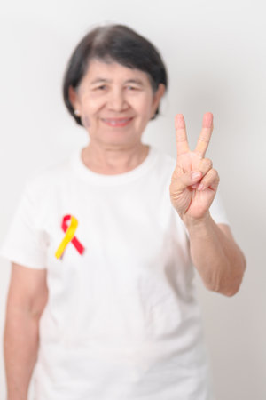 World hepatitis day awareness month, 28 July. elderly woman with Red and Yellow ribbon. Liver...