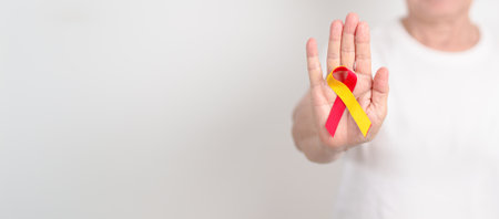 World hepatitis day awareness month, 28 July. elderly woman with Red and Yellow ribbon. Liver cancer, Jaundice, Cirrhosis, Failure, Enlarged, Hepatic Encephalopathy and Health conceptの写真素材