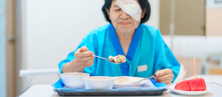 Senior Woman eating food after eye surgery in hospital . Eye disease, Cataract,  Glaucoma, Age Related Macular Degeneration, Diabetic Retinopathy, Lasik, World Glaucoma day and health treatmentの写真素材