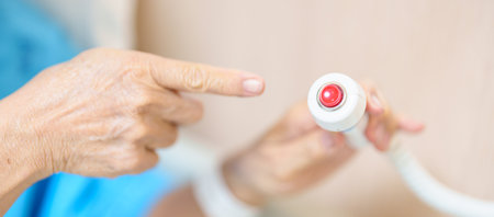 Elderly woman Patient hand holding and pressing emergency button in hospital room, calling nurse in...