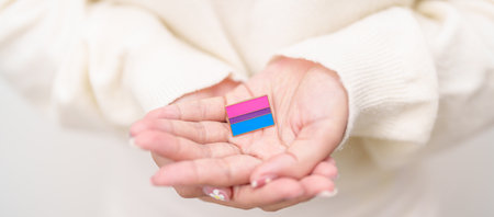 Bisexuality Celebrate Day and LGBT pride month, LGBTQ or LGBTQIA concept. Hand holding purple, pink...