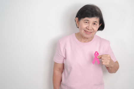 Elderly woman with pink Ribbon for Pink October Breast Cancer Awareness month, May Women Health, August World Breastfeeding week, Nursing Mothers, Pregnancy and Infant Loss Remembrance, Stillbirthの写真素材