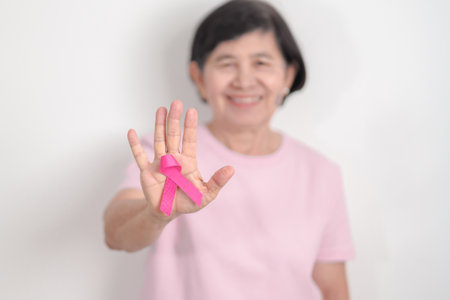 Elderly woman with pink Ribbon for Pink October Breast Cancer Awareness month, May Women Health, August World Breastfeeding week, Nursing Mothers, Pregnancy and Infant Loss Remembrance, Stillbirthの写真素材