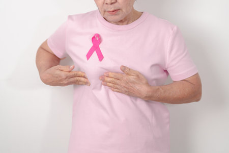 Elderly woman with pink Ribbon for Pink October Breast Cancer Awareness month, May Women Health, February World cancer day, support people life and illness. National cancer survivors monthの写真素材