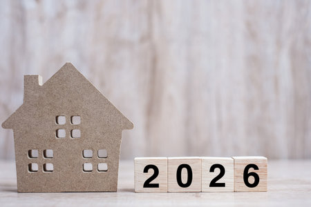 2026 Happy New Year with house model on table wooden background. Banking, real estate, investment,...